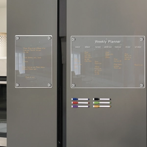 Close-up of magnetic acrylic weekly planner and blank board with six colored markers on fridge