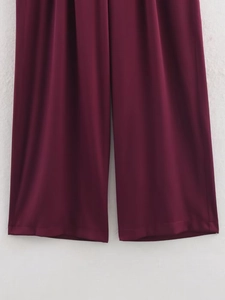 Detail der burgunderroten Hose mit weitem Bein, glattem Stofffall und präziser Saumnaht