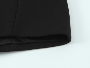 Detailed macro view of black fabric texture and fine stitching on a woman's jumpsuit