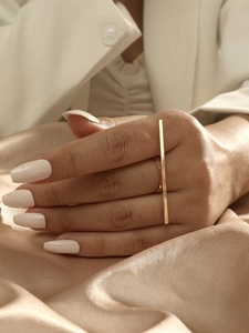 Detailed view of a gold geometric rectangular open ring worn on a finger