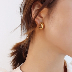 Elegant 18K gold plated titanium steel twist hoop earrings worn by a model