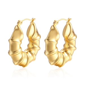 Chic 18K gold hollow bamboo earrings with glossy croissant texture on white backdrop