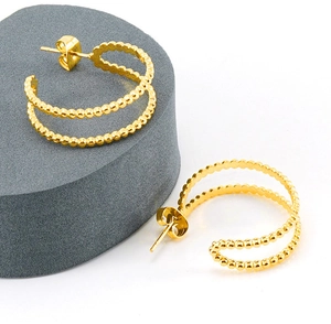 Detailed view of 18K gold plated double layer beaded hoop earrings on a stone display