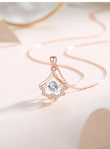 Macro shot of rose gold gingko leaf pendant necklace with shimmering white zircon detail