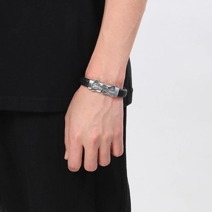 Men's black woven leather bracelet with silver cross and wings metal clasp