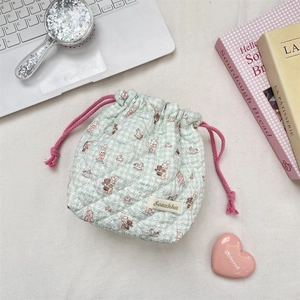 Detail of mint green quilted cartoon drawstring bag with bear and rabbit patterns