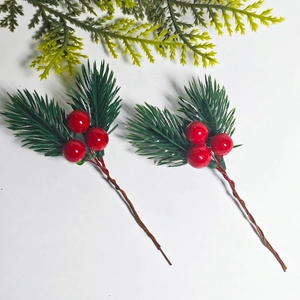 Close-up of artificial pine needles with red berries for DIY Christmas floral decor