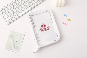 Close-up of clear A5 A6 PVC binder with cherry printed insert on a white desk