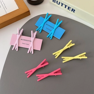 Candy-colored X-shaped matte hair clips in pastel macaron tones on a display card