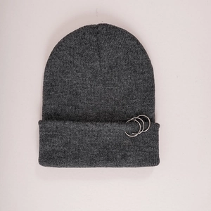 Détail du bonnet en maille gris foncé avec trois anneaux argentés et texture côtelée