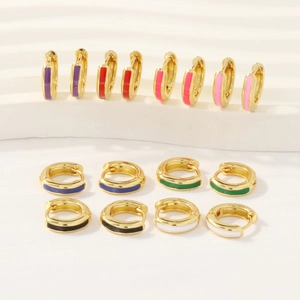 Detail of colorful enamel 18K gold plated hoop earrings in various vibrant shades
