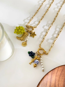 Detail of 18K gold plated paperclip necklaces with pearl grape and berry charms