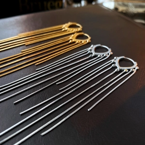 Détail macro de boucles d'oreilles gouttes or et argent avec longues chaînes serpents
