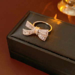 Sparkling zircon bow open ring in silver metal finish on a luxury jewelry box