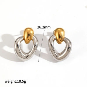 Détail montrant des boucles d'oreilles cœur bicolores avec taille 26,2mm et poids 18,5g