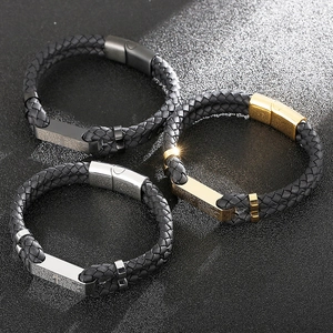 Détail de bracelets en cuir tressé avec plaques en métal gravées en or, argent et noir mat