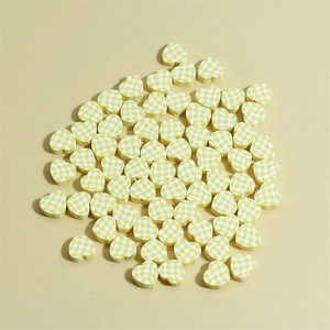 Dettaglio di perline di argilla da 10mm a forma di cuore con motivi a scacchi gialli per DIY