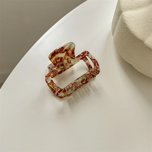 Detail of square cutout acetic hair clip with amber leopard pattern and VIGY FRANCE text