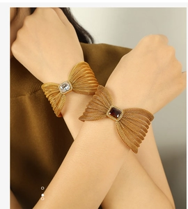 Close-up of bow-shaped mesh bracelets with sparkling crystals on a female model's wrist