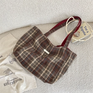 Close-up of vintage plaid tote bag showing thick checkered canvas texture and shoulder strap