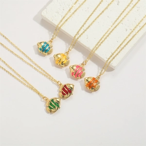 Detail view of colorful fish pendant necklaces in vibrant blue, pink, and yellow enamel
