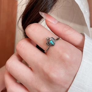Macro shot of vintage crown ring with turquoise stone and ornate bronze metal carving