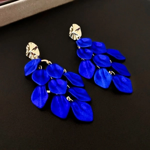 Detailed close-up of blue petal tassel earrings with gold irregular textured studs