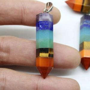 Detailed macro of a seven chakra hexagonal column pendant made of layered natural stones