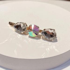 Macro shot of gold bobby pin with sparkling colorful rhinestones and crystal stones