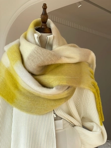 Close-up of yellow and beige gradient plaid scarf with soft fringe and fuzzy texture