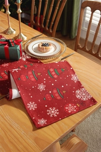 Close-up of a festive red Christmas table runner with snowflake and ornament prints