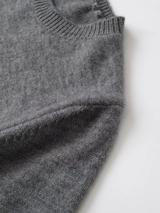 Detailed close-up showing the fine grey knit texture and shoulder seam craftsmanship