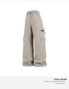 Detalle de los pantalones cargo caqui con bolsillos grandes, cordón y diseño de cremallera