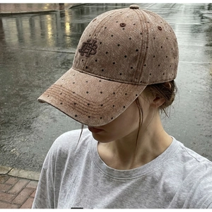 Close-up of vintage brown cotton baseball cap with polka dots and letter embroidery