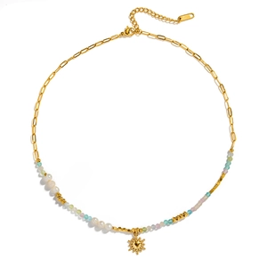 Detailed shot of a sun pendant necklace with freshwater pearls and colorful stone beads