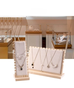 Detailed view of large wooden necklace display stands with multiple top slots and beige velvet