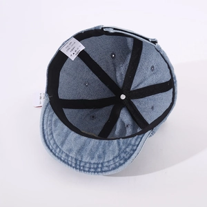 Détail intérieur de la casquette bébé en jean avec étiquette 100% coton et structure 6 pans