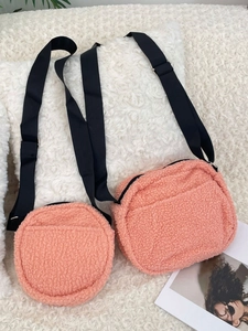 Plush faux shearling crossbody bags in coral orange with adjustable nylon straps