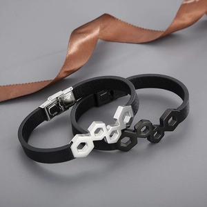 Detail of black woven leather bracelets with silver and black honeycomb patterned steel clasp