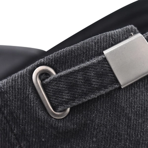 Macro view of adjustable silver metal buckle and stitching on washed denim baseball cap