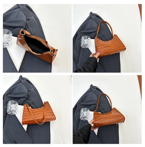 Detail view showing crocodile pattern leather texture and black lining of the brown baguette bag