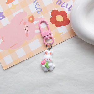 Close-up of pink resin rabbit charm with tulip and gold lobster clasp keychain accessory