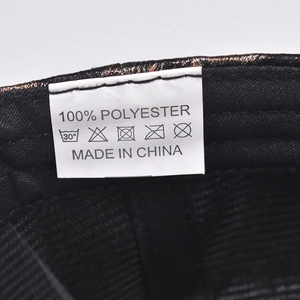 Detailed macro view of the 100% polyester fabric care label on a leopard baseball cap