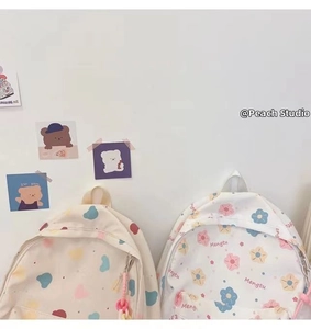 Detail of cute Korean student backpacks featuring colorful floral and heart patterns