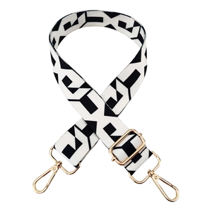 Adjustable black and white geometric woven bag strap with golden metal hardware