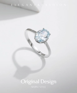 Close-up of oval-cut light blue gemstone ring with minimalist silver band and shadow