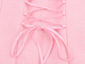 Detailed view of pink tweed fabric texture with decorative crisscross lace-up bow design