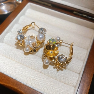 Detailed macro shot of vintage floral earrings with pearls and crystals on velvet padding