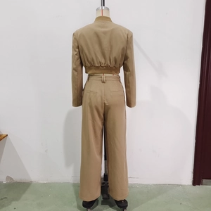 Detail view of a tan two-piece women's set with cropped blazer and wide-leg trousers