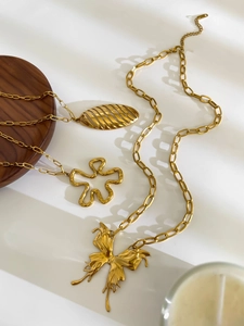 Detail of gold-plated butterfly, star, and oval pendants on elegant thin link chains